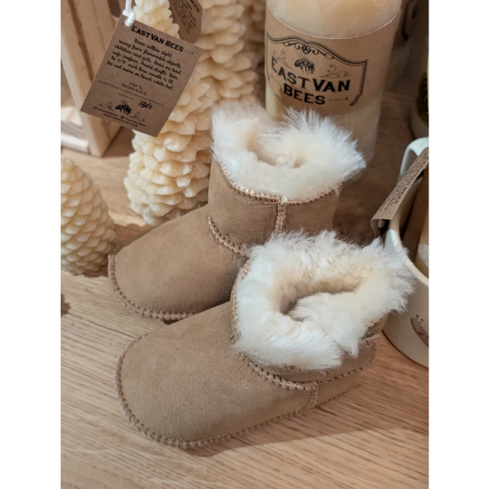 Tan suede sheepskin baby booties with white fur trim and gold chain