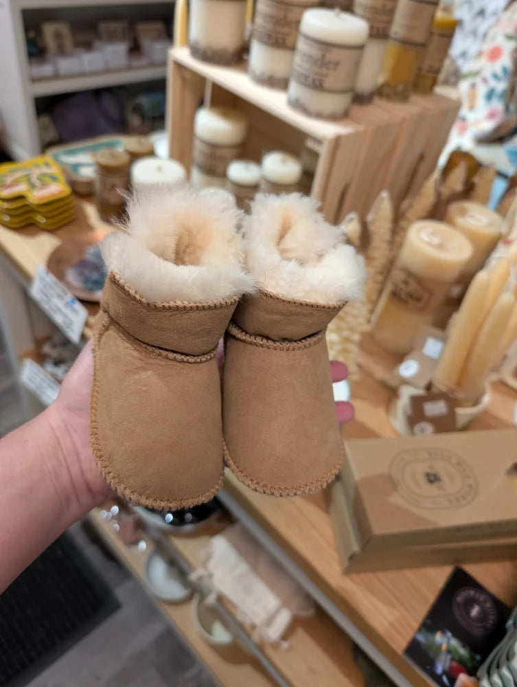 Tan UGG sheepskin baby booties with white fur lining
