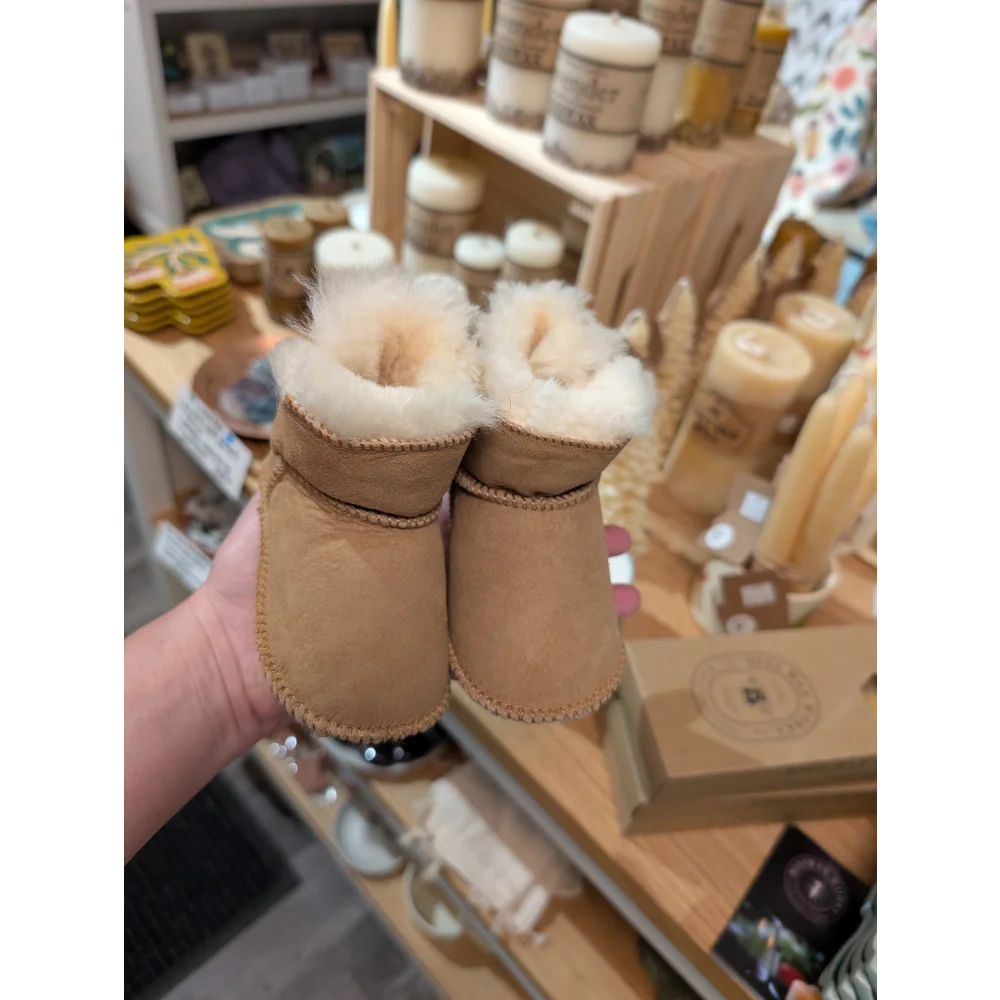 Tan UGG sheepskin baby booties with white fur lining