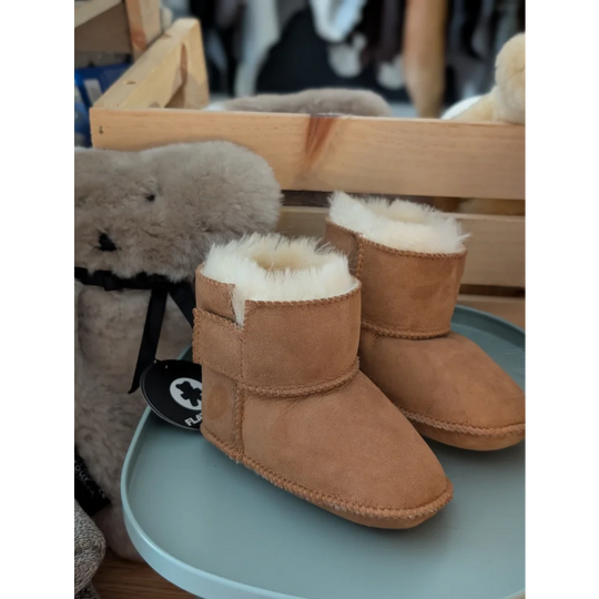 Tan sheepskin baby booties with shearling lining and star design