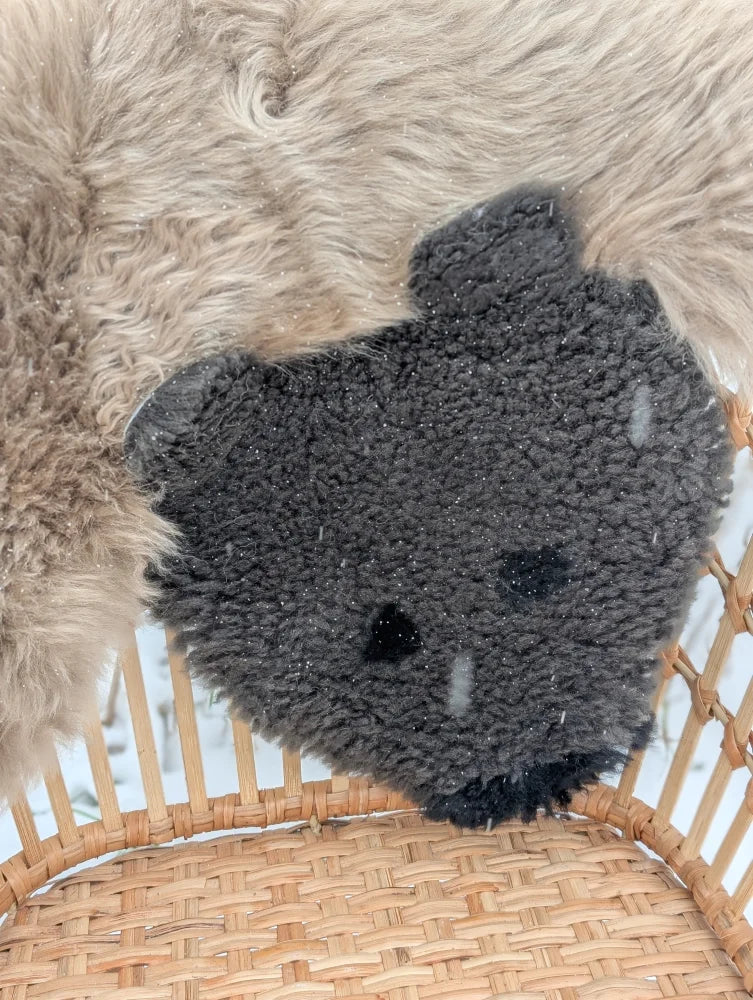 A hand made dark gray plush teddy bear cushion with soft merino sheepskin texture perfect for grizzly bear rug decor