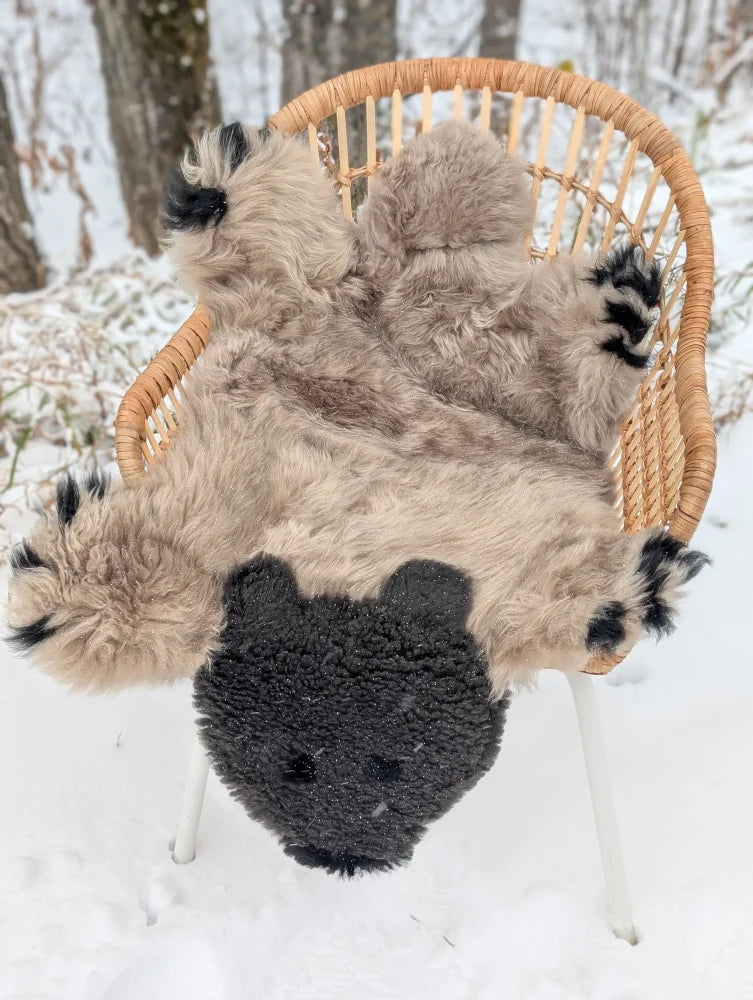 A hand made sheepskin bear rug resembling a light brown and black grizzly bear with a shaggy texture