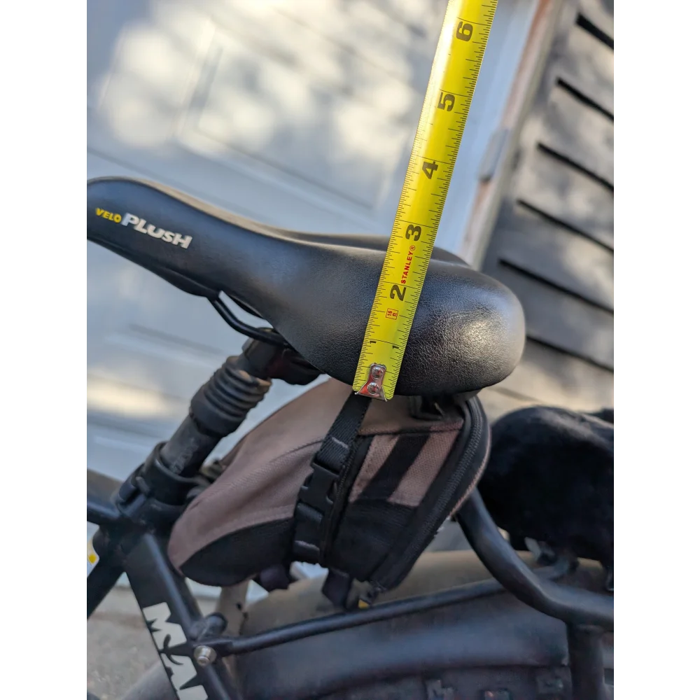 Black merino sheepskin bicycle seat with yellow tape for height adjustment