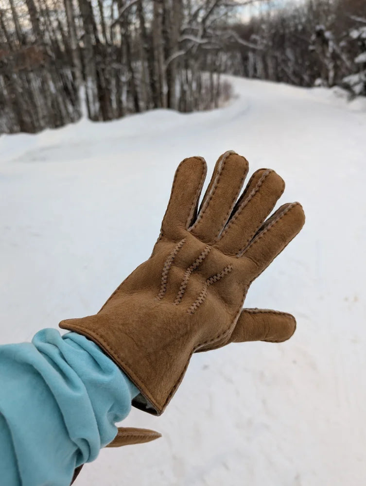 Brown suede glove with visible stitching along the fingers and back.