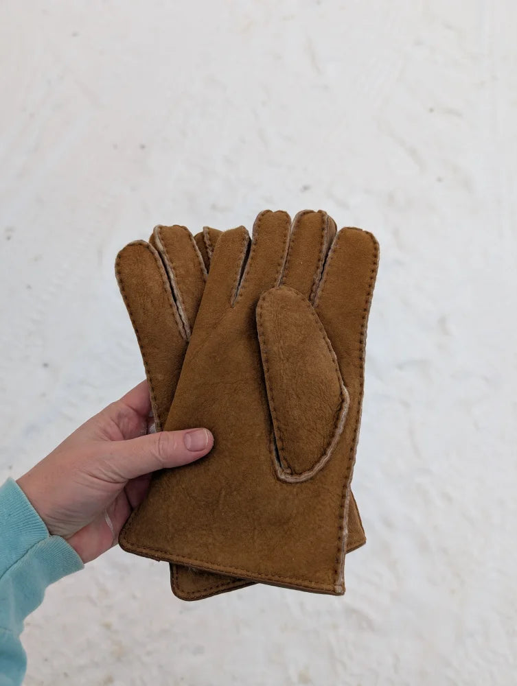 Tan sheepskin gloves with a soft, plush interior and neatly stitched edges.