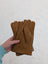 Tan sheepskin gloves with a soft, plush interior and neatly stitched edges.