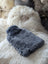Soft sheepskin hot water bottle cover with insert on fluffy rug for chilly nights