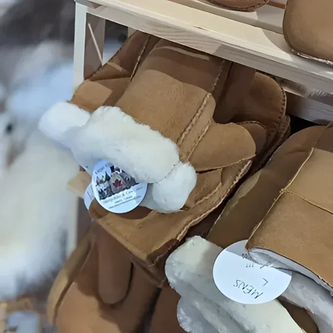 Cozy tan sheepskin mittens with white fur trim and round tag