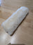 White fluffy sheepskin noseband cover on wooden floor