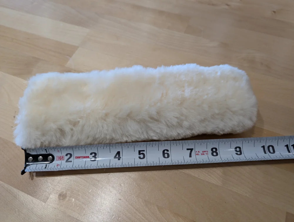 White fluffy sheepskin noseband cover with black tape measure