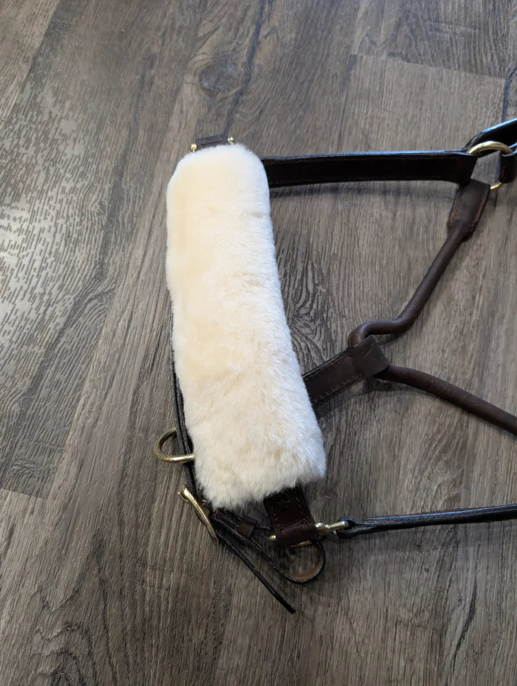 White sheepskin noseband cover with brown leather and metal accents