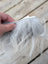 A fluffy gray and white sheepskin sample square with soft faux fur texture perfect for cozy crafts and decor