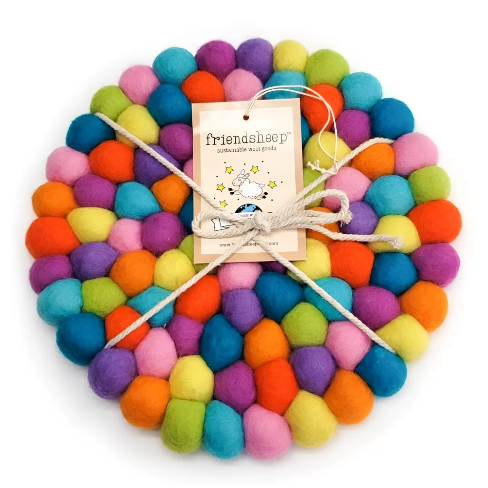 A colorful round eco coaster made of vibrant wool balls in pink blue orange purple and green from shiny happy eco coasters