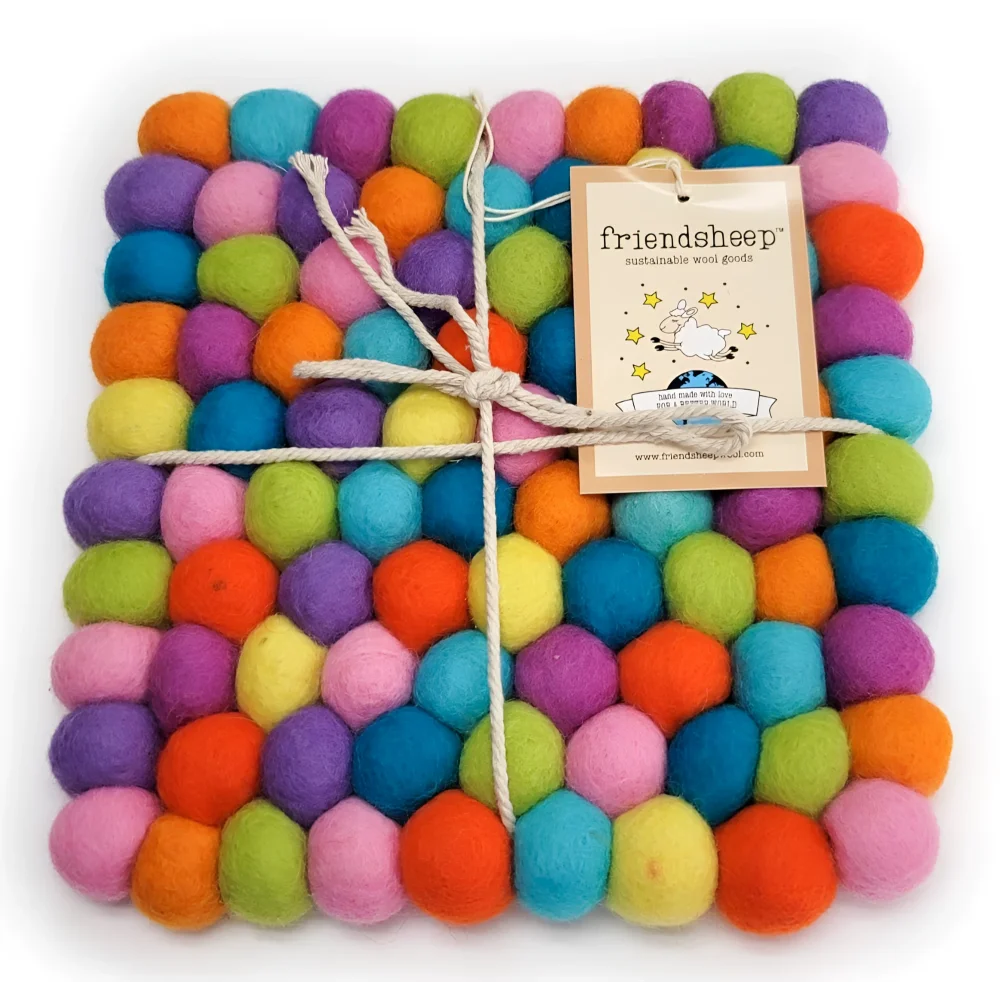 A colorful square eco coaster made of tightly packed wool balls in vibrant rainbow hues perfect as an eco trivet