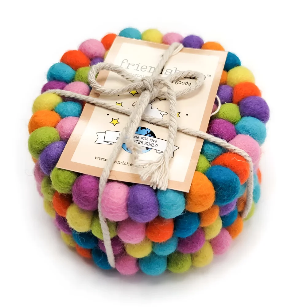 A colorful set of eco coasters made from felt balls in rainbow hues tied with natural twine for serving use