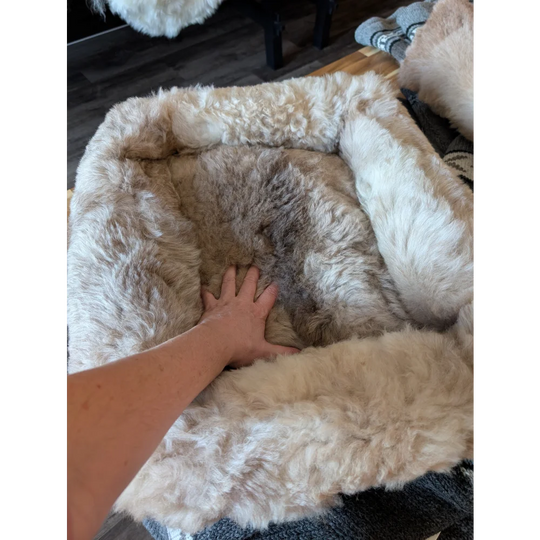 Cozy beige and brown highland sheepskin pet bed with plush faux fur interior