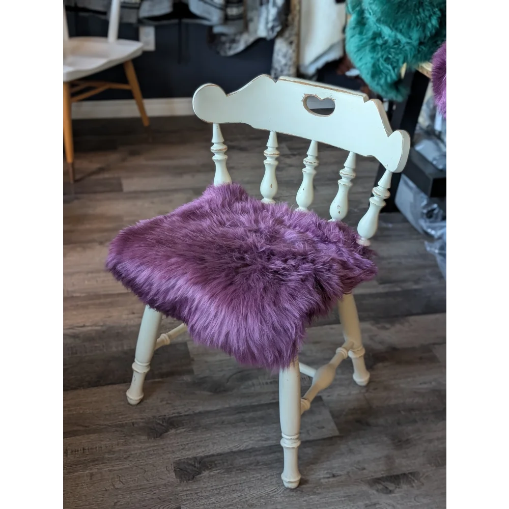 Plum purple merino sheepskin chair pad with lavender faux fur on white wooden spindle frame