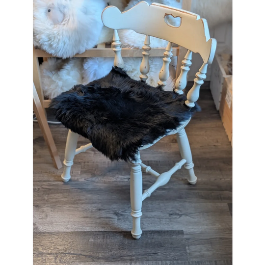 Black faux fur sheepskin chair pad in gorgeous black merino with white wooden spindle back