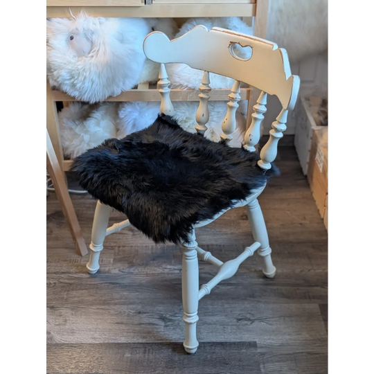 White spindle chair with gorgeous black merino sheepskin pads