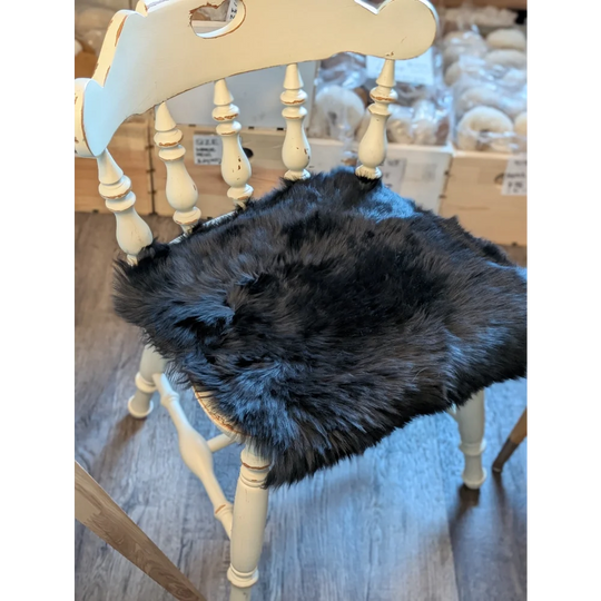 Gorgeous black merino sheepskin chair pad with faux fur, wooden legs and spindles in cream