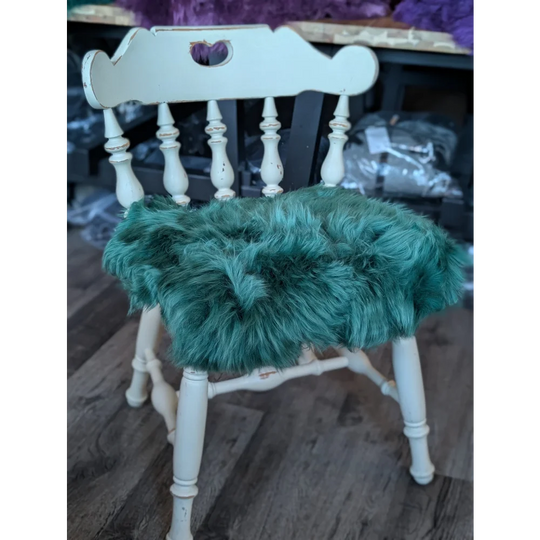 Gorgeous green merino sheepskin chair pad with white wooden spindle back