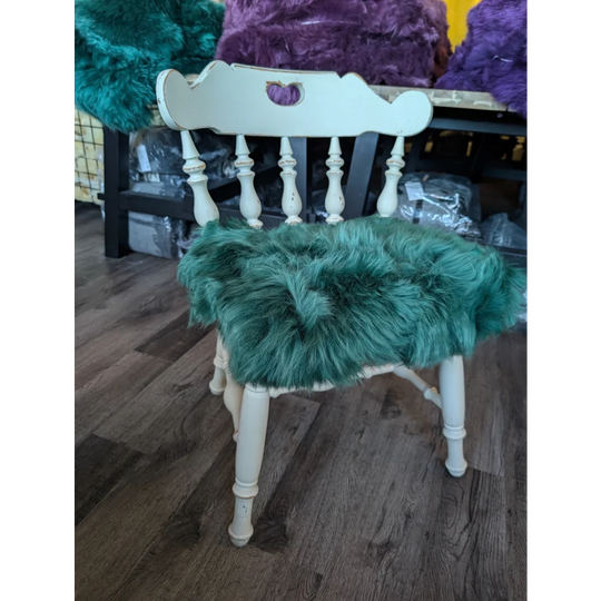 Gorgeous green merino sheepskin chair pads on white wooden frame