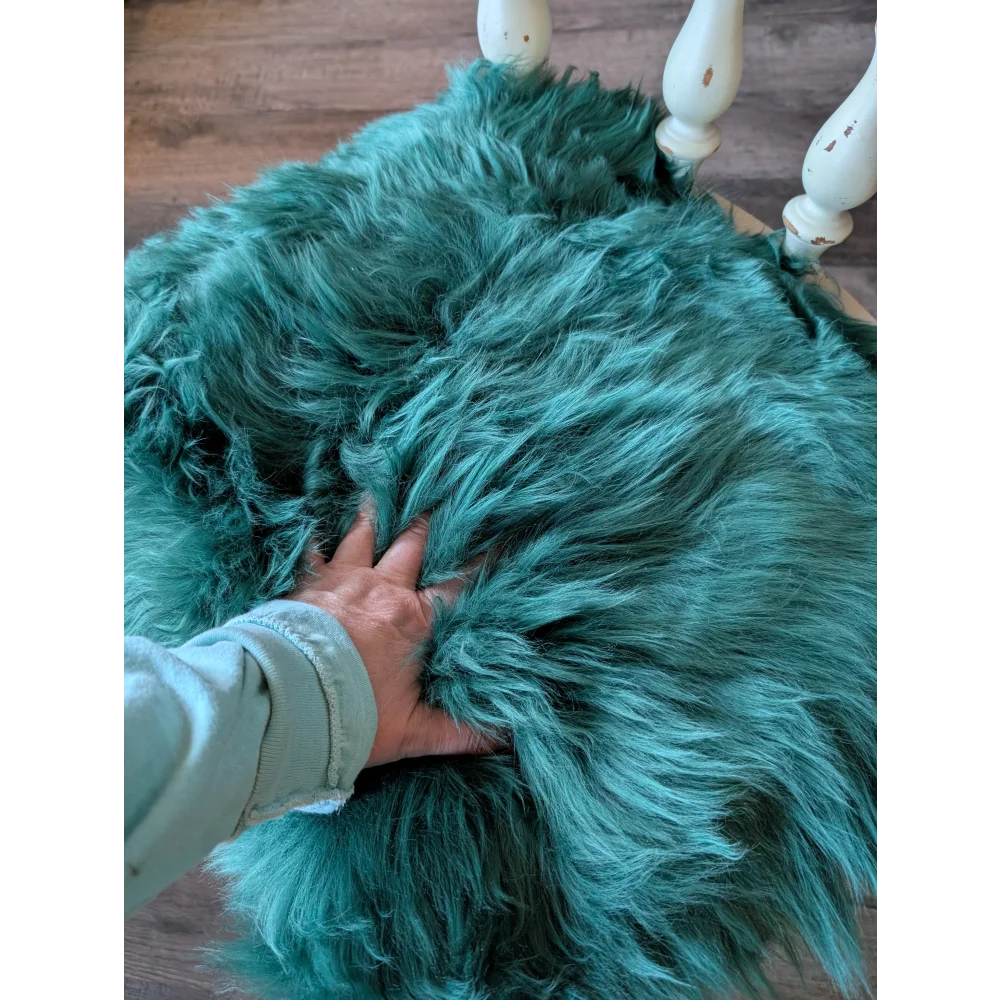 Gorgeous green merino sheepskin chair pads on teal faux fur throw