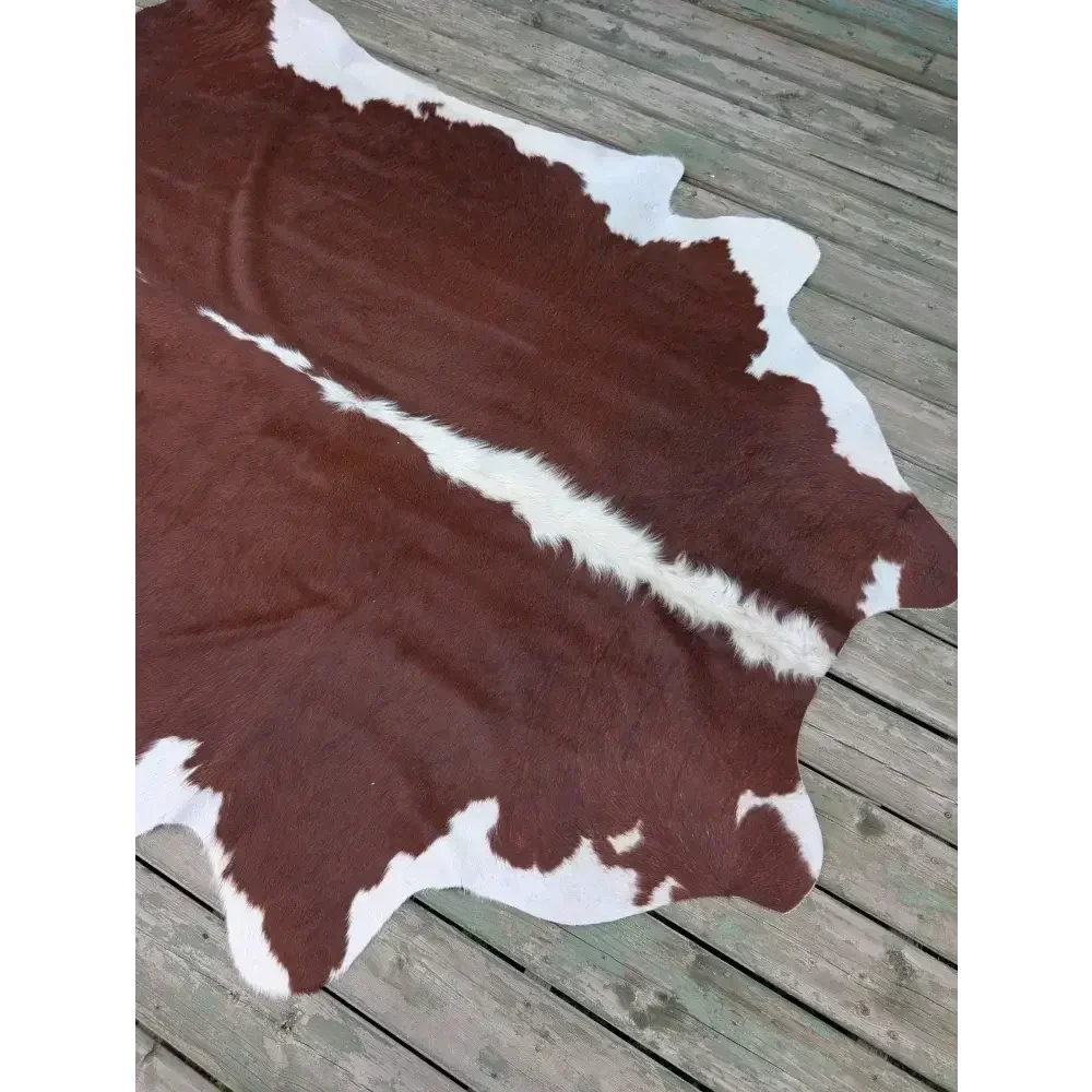 Large 85’’ x 74.5’’ cowhide rug with brown white patches and leather texture