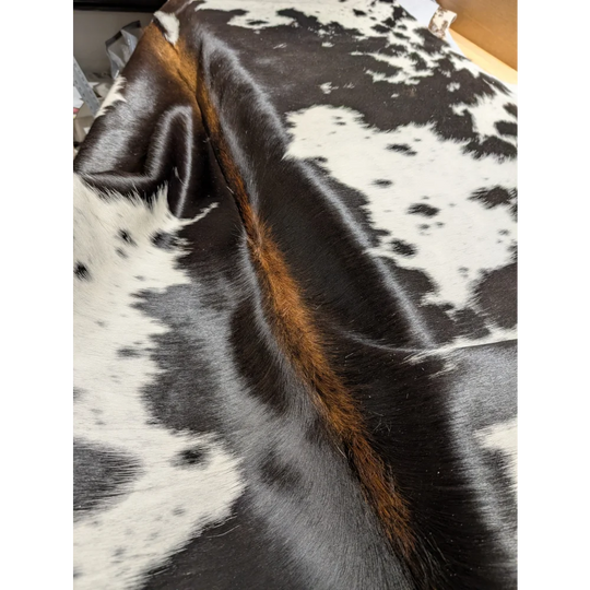 Large cowhide rug with unique brown fur edges, 85.5x72 inches