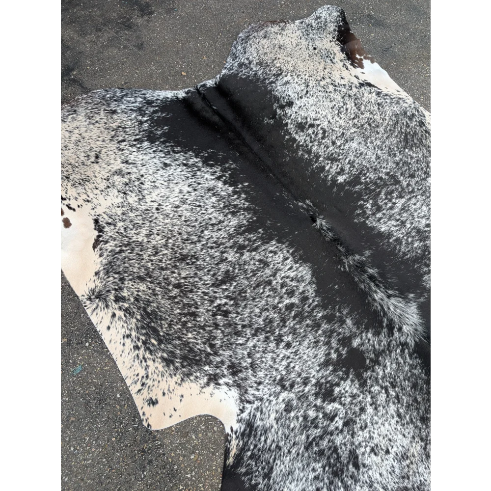 Large cowhide rug with black and white speckled pattern and leather texture
