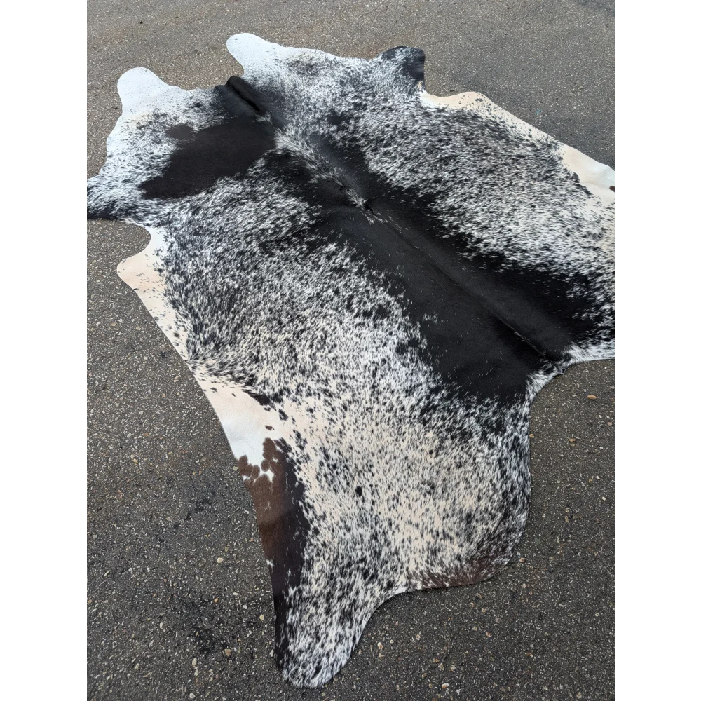 Large cowhide rug with black and white speckled pattern and leather texture