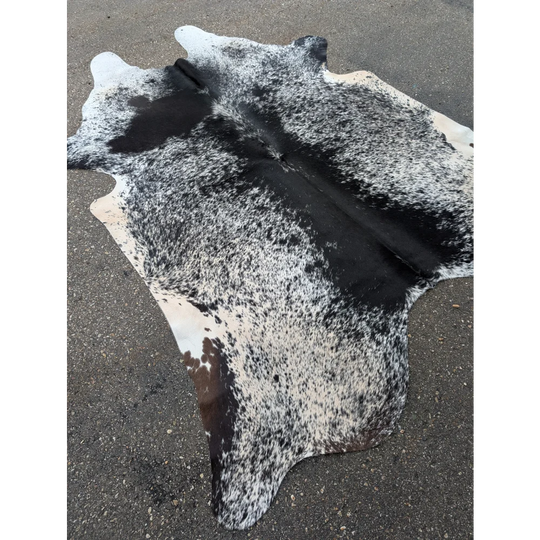 Large cowhide rug with black and white speckled pattern and leather texture