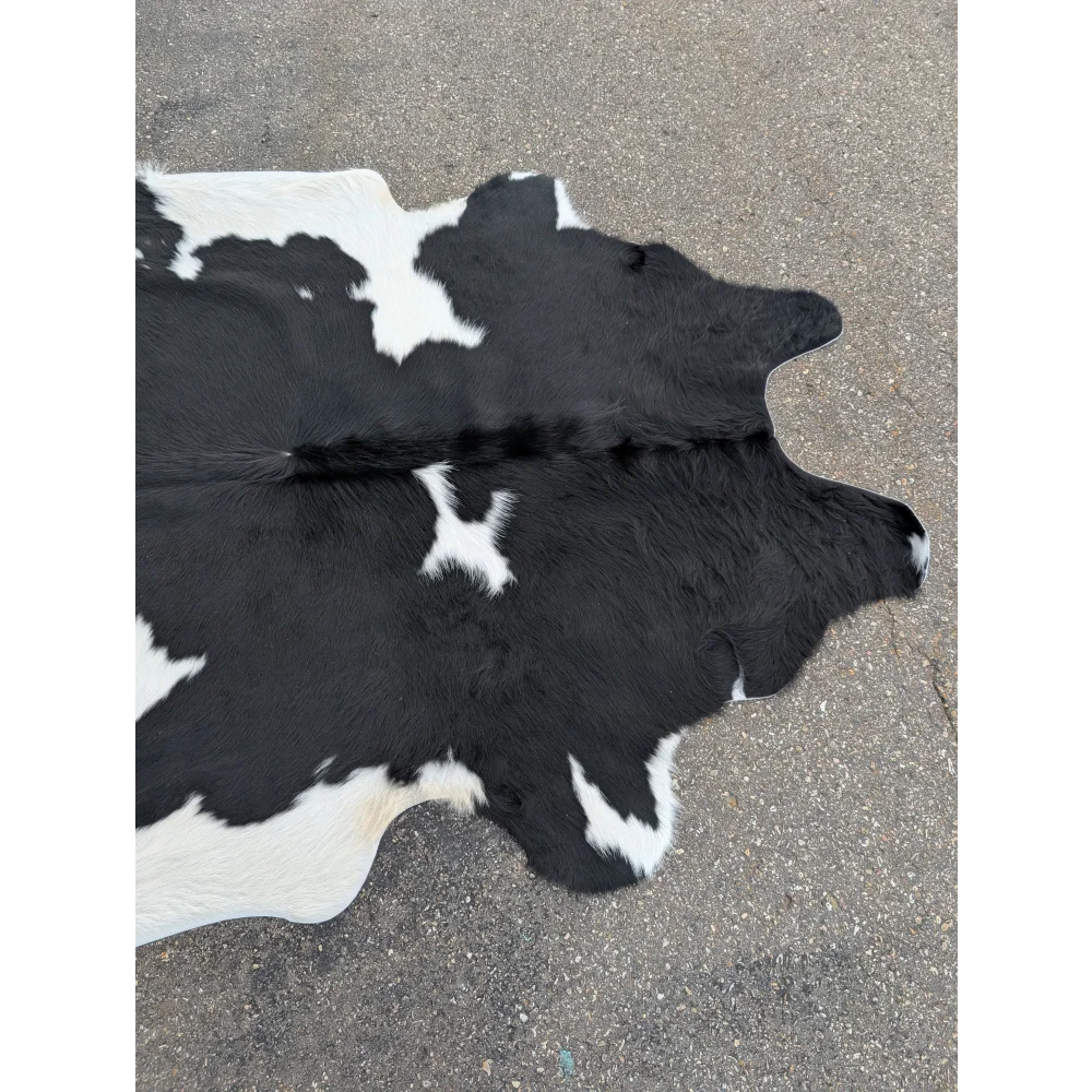 Large cowhide rug with black and white patches and natural leather texture