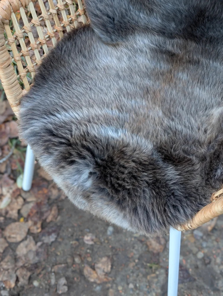 A softbrit#2 40 x 24 gray british isles sheepskin faux fur throw draped over a wicker chair