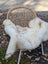 A soft brit 4 british isles sheepskin throw in white and beige faux fur draped over a woven wicker chair