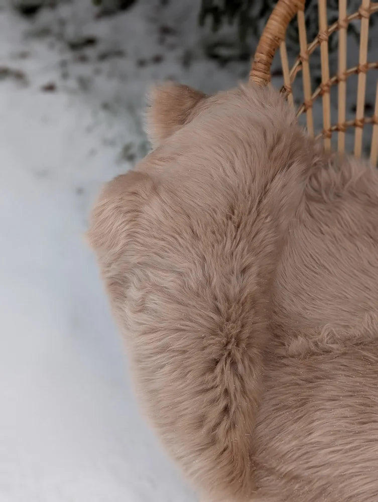 A soft light taupe merino sheepskin throw blanket with plush texture perfect for cozy mid october vibes