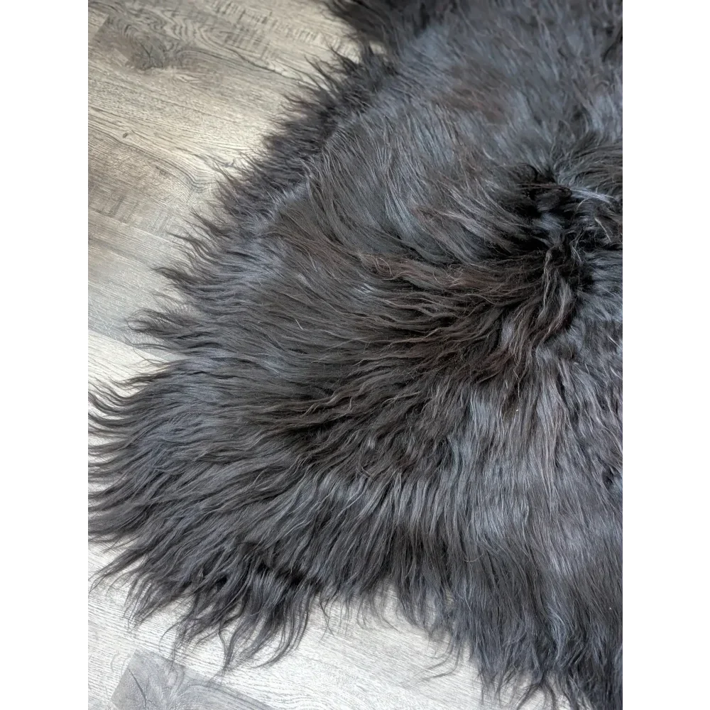 Massive 57x32 black Icelandic sheepskin rug with soft, thick fur on wood floor