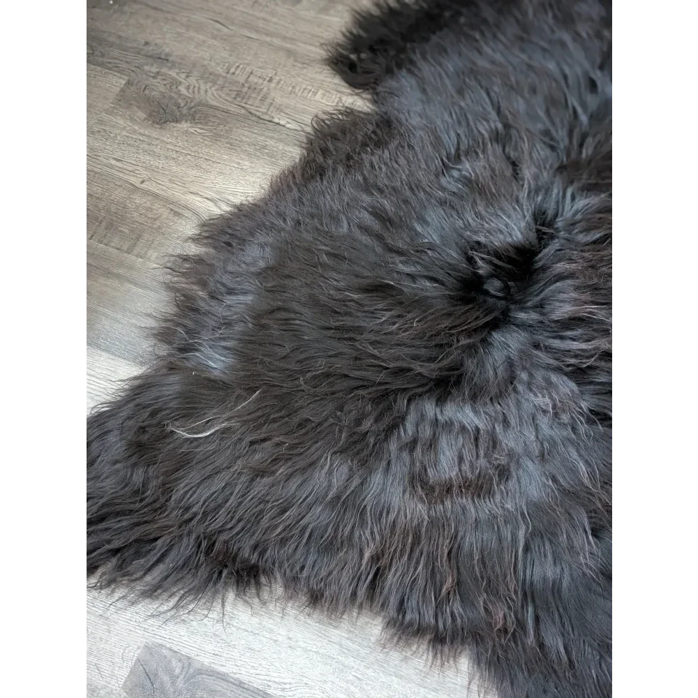 Massive 59x32 black Icelandic sheepskin rug on wood floor
