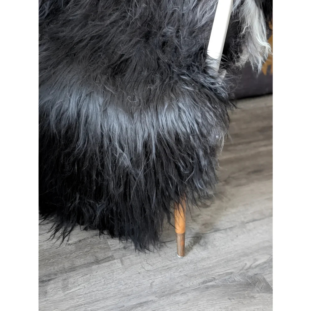 Black Icelandic sheepskin chair with shaggy fur and wooden legs