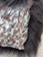 A speckled cowhide plush pillow with browny black natural cowhide and long wool texture for cozy decor