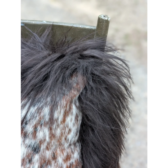 Black faux fur trim on the shoulder of a speckled cowhide and browny black icelandic knit with long wool details