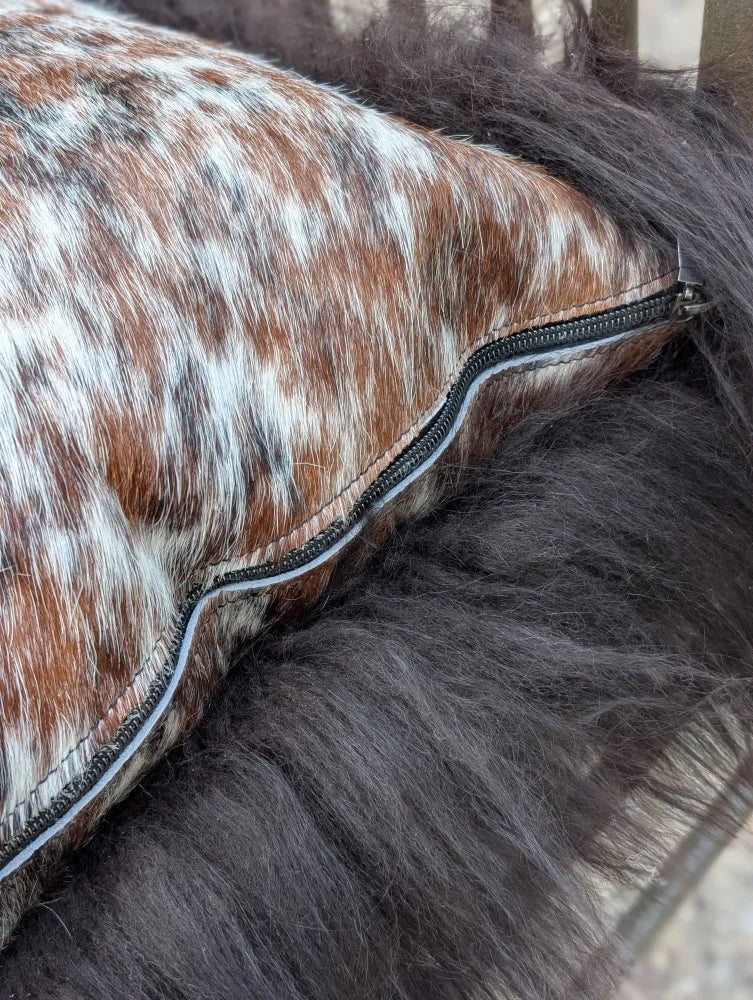 Brown and white spotted natural cowhide pillow with black zipper perfect for long wool décor and sewing machines users