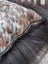 Brown and white spotted natural cowhide pillow with black zipper perfect for long wool décor and sewing machines users