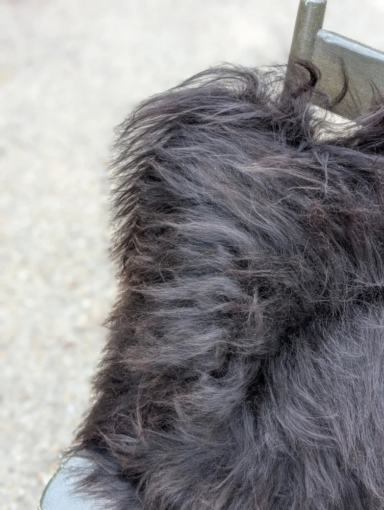 A thick dark gray faux fur collar with long wool texture on speckled natural cowhide browny black icelandic jacket
