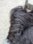 A thick dark gray faux fur collar with long wool texture on speckled natural cowhide browny black icelandic jacket