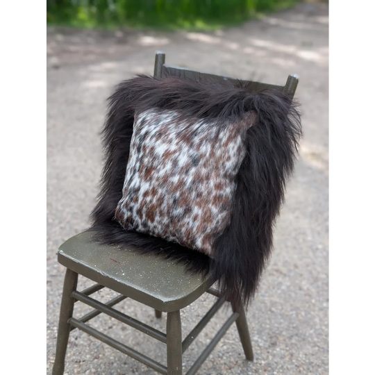 Faux fur throw pillow with white brown and black spotted pattern inspired by natural cowhide and long wool textures