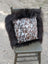 A cozy square pillow with natural cowhide speckled brown white and black pattern framed by plush dark long wool fur