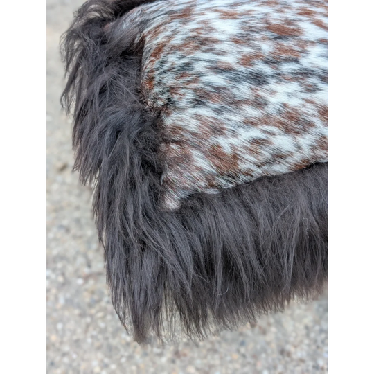 A plush dark gray faux fur trim with a speckled natural cowhide patch on the speckled cowhide and browny black icelandic