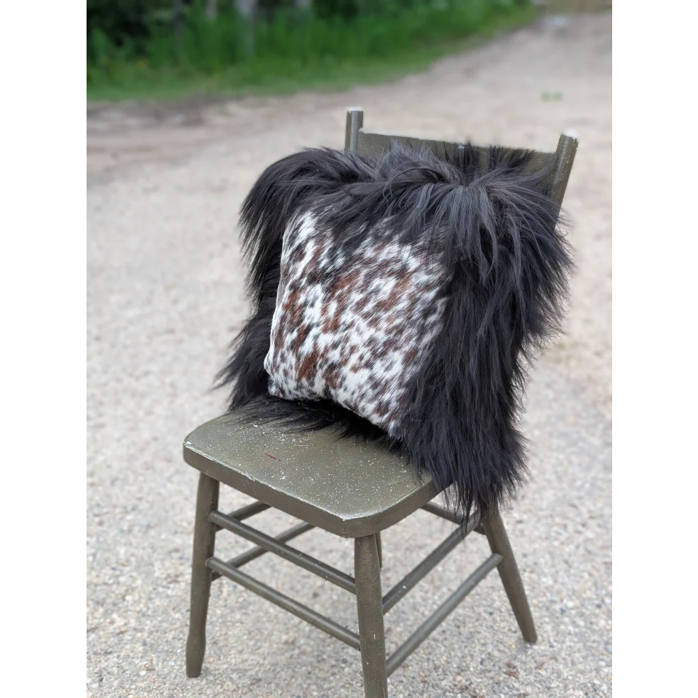Black and white speckled natural cowhide pillow with long wool black shaggy trim perfect for sewing machines decor