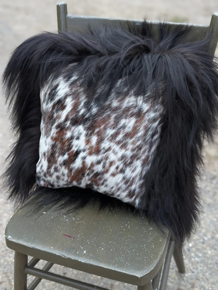 Black and white natural cowhide pillow with long wool black fur trim from the speckled cowhide and natural black icelandic collection